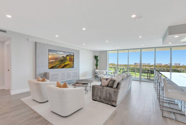 living room with floor to ceiling windows and light hardwood / wood-style flooring