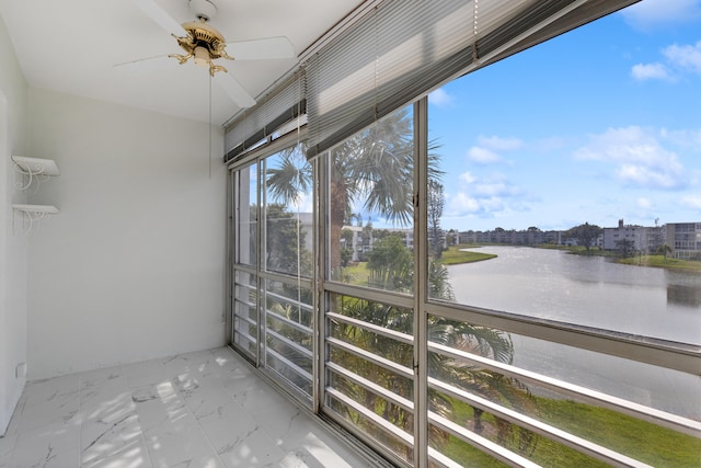 unfurnished sunroom with ceiling fan and a water view