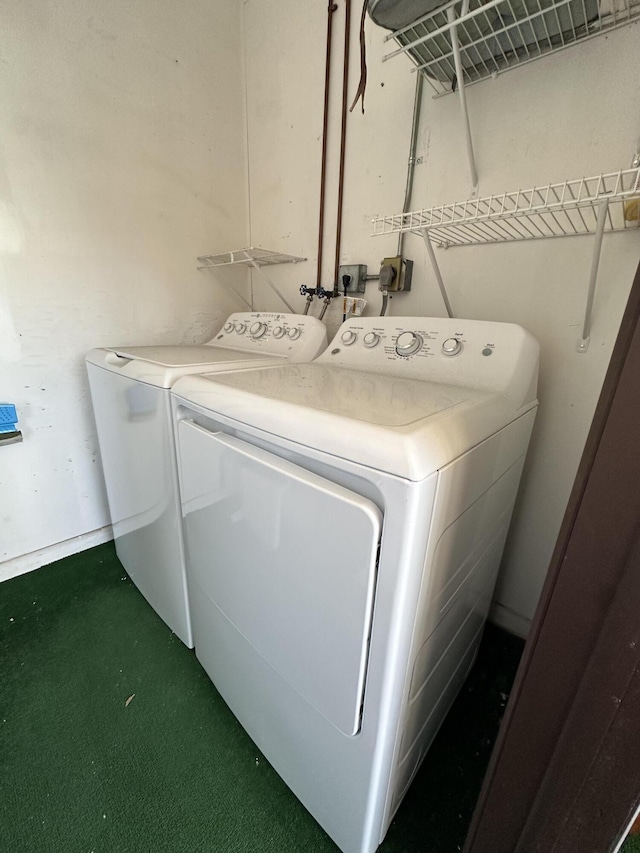 clothes washing area featuring dark carpet and washing machine and clothes dryer