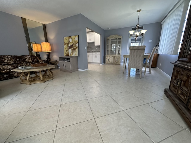 dining area with light tile patterned floors, sink, and a chandelier