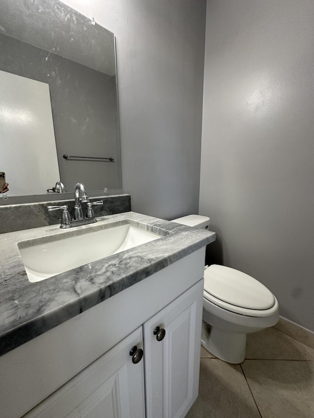 bathroom featuring toilet, vanity, and tile patterned flooring