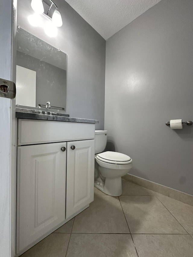 bathroom featuring a textured ceiling, tile patterned floors, vanity, and toilet