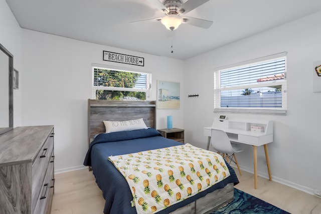 bedroom with ceiling fan, light wood-type flooring, and multiple windows