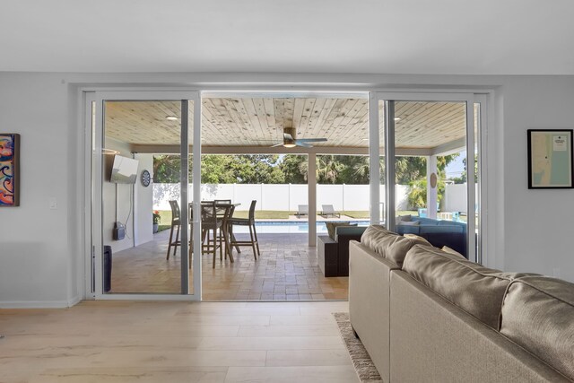 living room with wood ceiling, plenty of natural light, light wood-type flooring, and ceiling fan