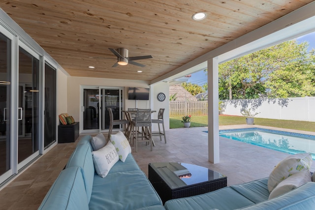 view of patio with an outdoor living space, ceiling fan, and a fenced in pool