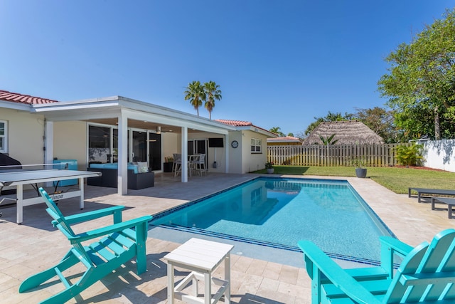 view of pool featuring outdoor lounge area, a patio, and a yard