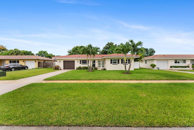 ranch-style house featuring a garage and a front lawn