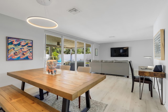 dining area with light hardwood / wood-style floors and french doors