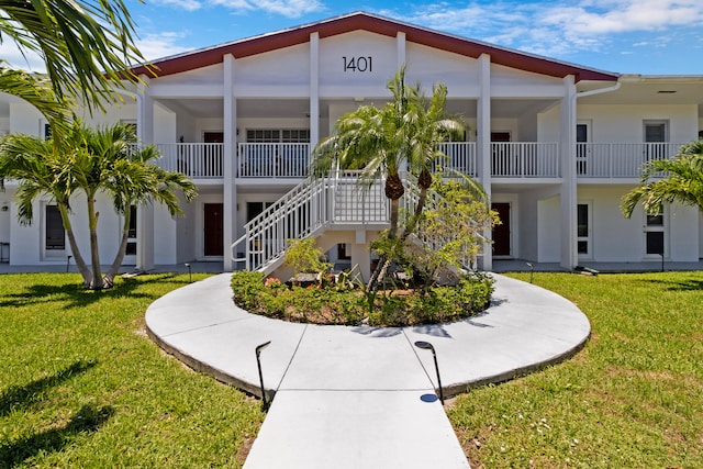 view of front of home featuring a front lawn and a balcony