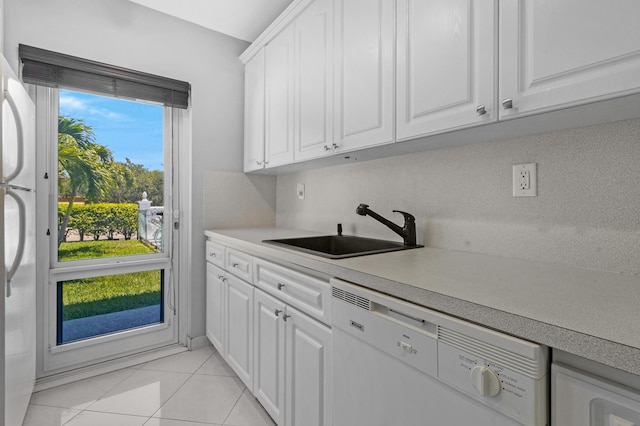 kitchen featuring sink, white cabinetry, white appliances, and light tile patterned floors