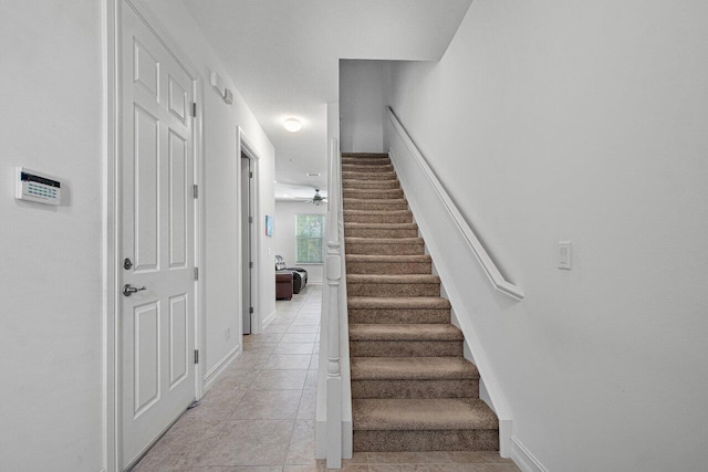 stairs with ceiling fan and tile patterned flooring