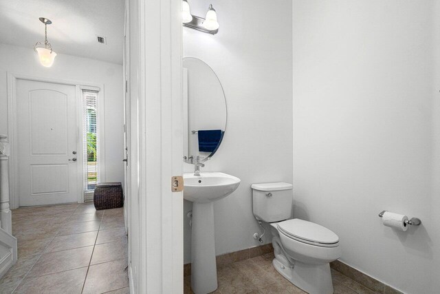 bathroom featuring sink, toilet, and tile patterned flooring