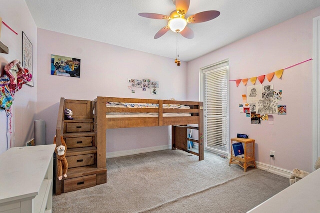 carpeted bedroom with ceiling fan and a textured ceiling