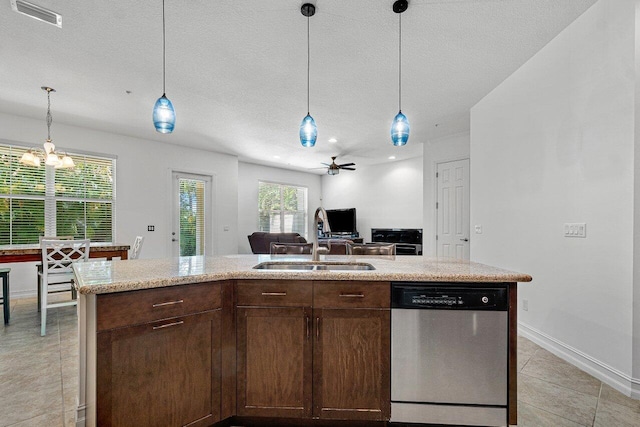 kitchen featuring ceiling fan with notable chandelier, stainless steel dishwasher, a center island with sink, and sink