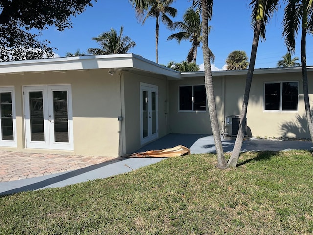 exterior space featuring stucco siding, cooling unit, a patio, and french doors