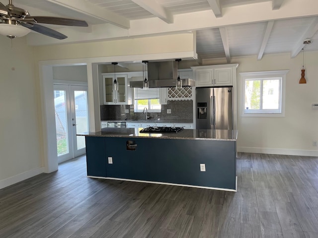 kitchen featuring stainless steel refrigerator with ice dispenser, backsplash, white cabinetry, a kitchen island, and a sink