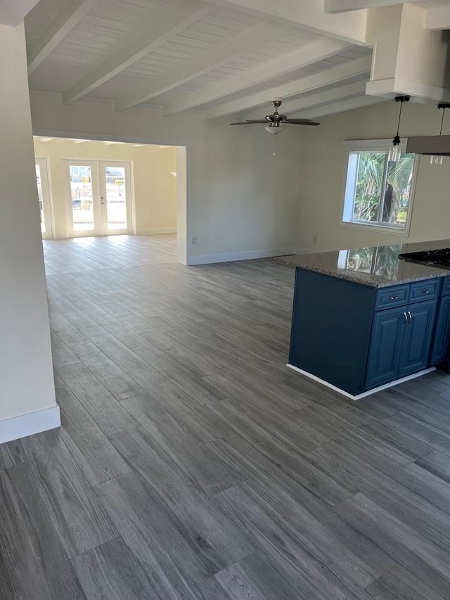 kitchen with a healthy amount of sunlight, blue cabinetry, baseboards, and open floor plan