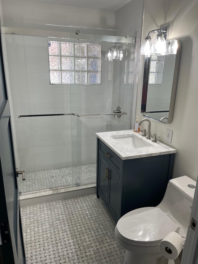 full bathroom with vanity, a shower stall, and toilet