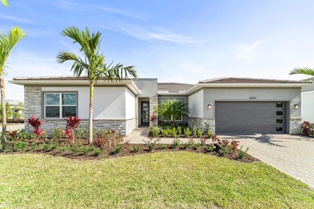 view of front of home featuring a garage and a front lawn