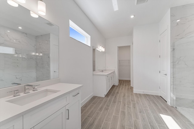 bathroom with vanity and a tile shower