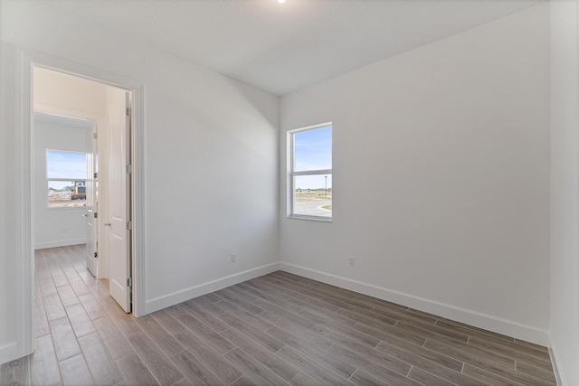 spare room with plenty of natural light and wood-type flooring