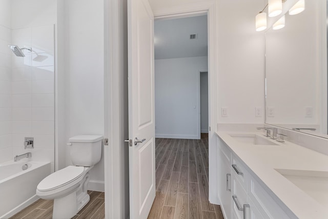 full bathroom with vanity, tiled shower / bath, and toilet