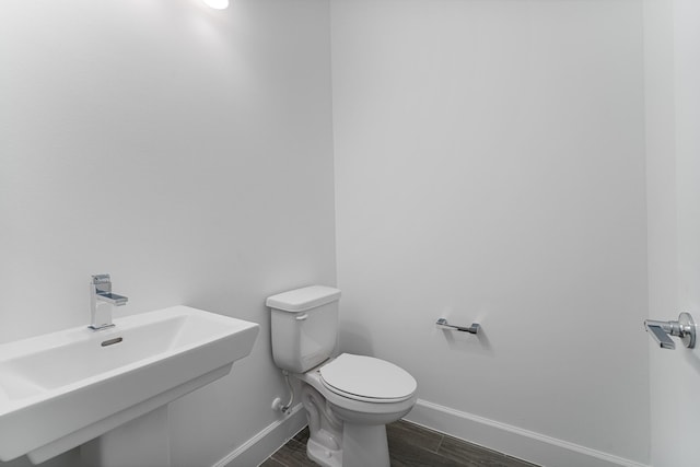 bathroom featuring sink, hardwood / wood-style flooring, and toilet