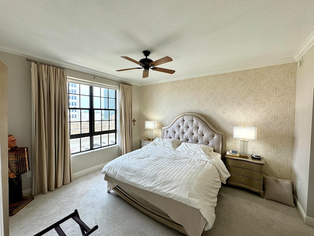 carpeted bedroom with ornamental molding, ceiling fan, and a textured ceiling