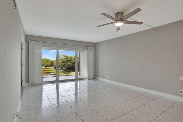 spare room with ceiling fan and light tile patterned floors