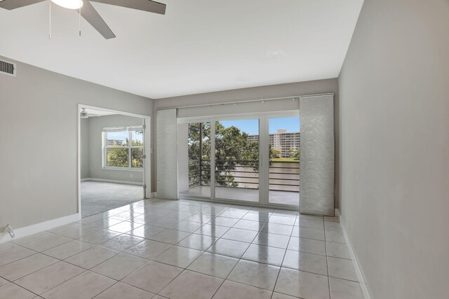 empty room featuring ceiling fan, light tile patterned floors, and track lighting