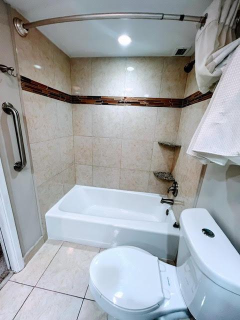 bathroom featuring tile patterned flooring, vanity, and shower / bathtub combination with curtain