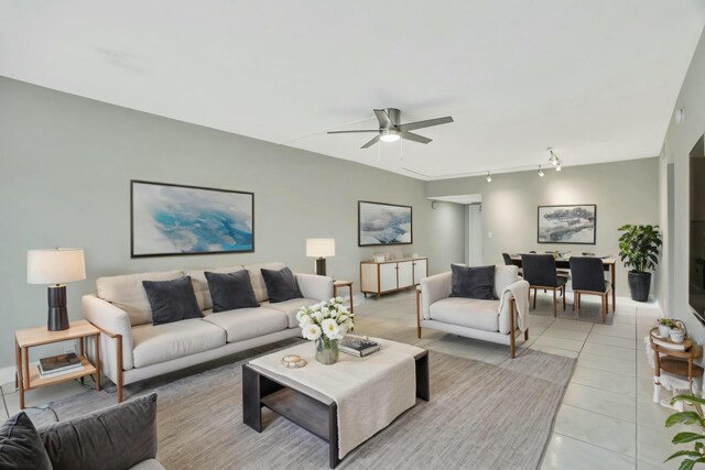 spare room featuring track lighting, ceiling fan, and light tile patterned flooring