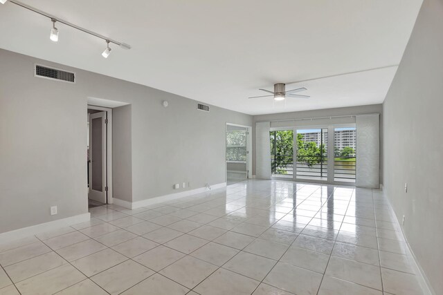 tiled empty room featuring ceiling fan