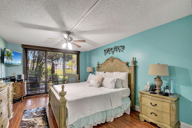 bedroom with a textured ceiling, hardwood / wood-style flooring, ceiling fan, and access to exterior