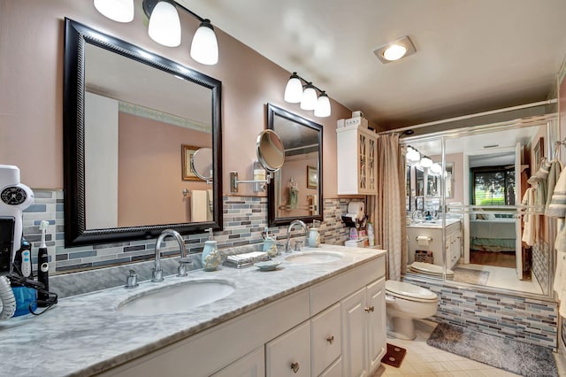 bathroom featuring tile floors, double vanity, tasteful backsplash, and toilet