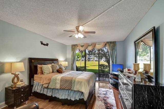 bedroom featuring wood-type flooring, a textured ceiling, and access to outside