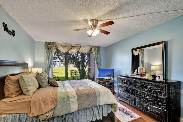 bedroom with wood-type flooring, ceiling fan, and a textured ceiling