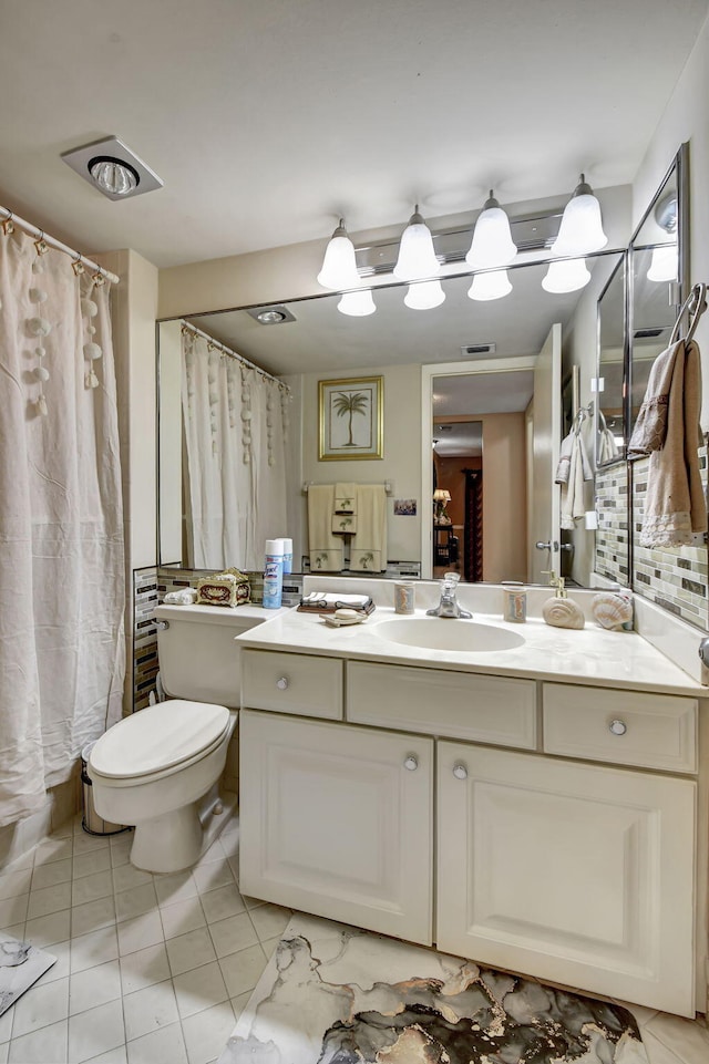 bathroom with tile floors, toilet, and vanity