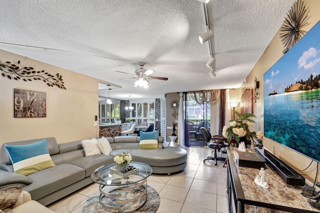 living room with plenty of natural light, a textured ceiling, light tile flooring, and rail lighting