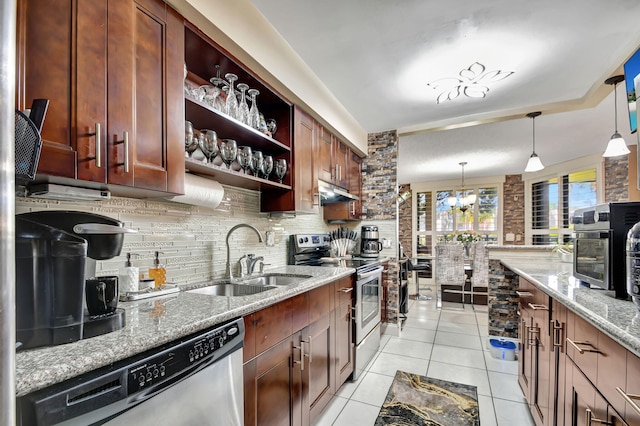 kitchen featuring stainless steel appliances, light stone counters, light tile floors, hanging light fixtures, and sink