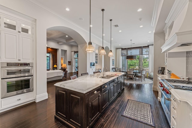 kitchen featuring decorative light fixtures, white cabinets, dark hardwood / wood-style floors, stainless steel appliances, and sink