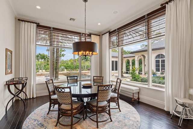 dining space featuring a healthy amount of sunlight, ornamental molding, and dark wood-type flooring