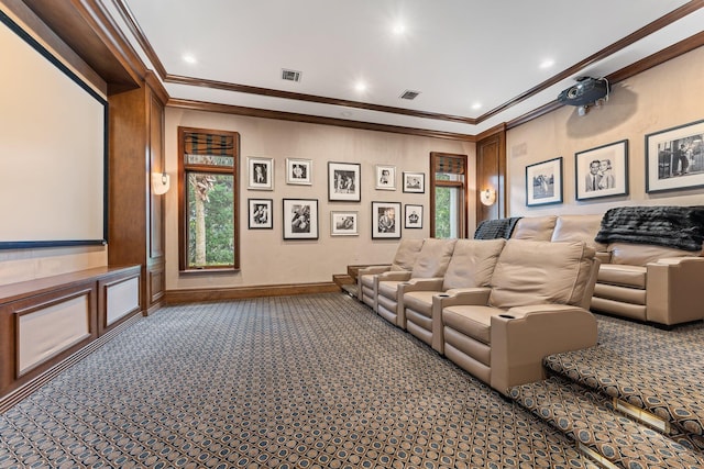 home theater featuring a wealth of natural light, ornamental molding, and dark carpet