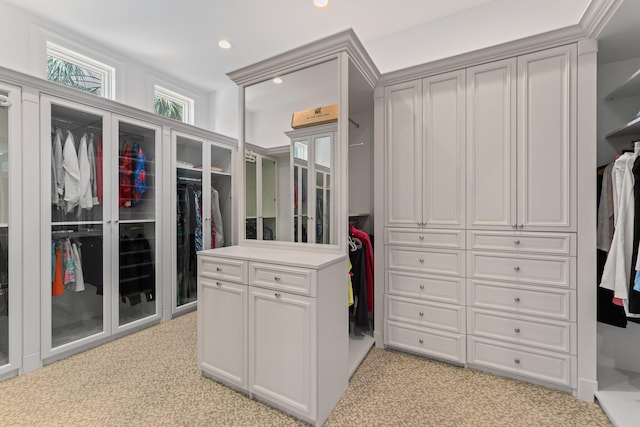 walk in closet featuring light colored carpet