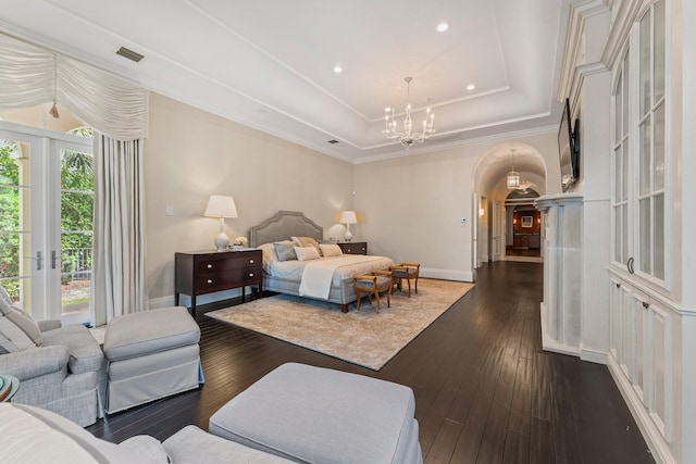 bedroom with dark wood-type flooring, a tray ceiling, access to outside, and multiple windows