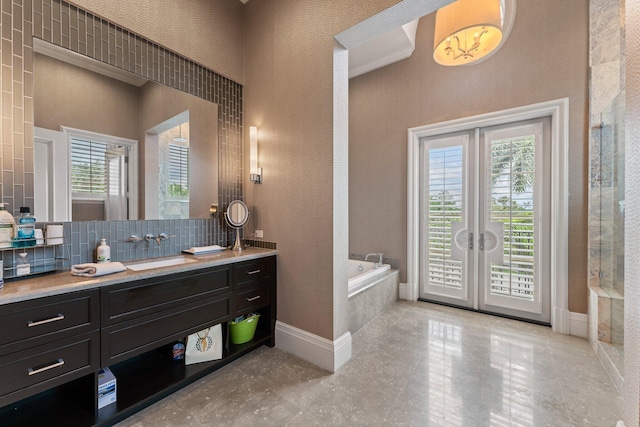 bathroom featuring a wealth of natural light, tasteful backsplash, tile flooring, and vanity