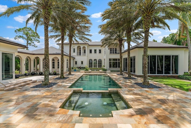 view of swimming pool with a patio and an in ground hot tub