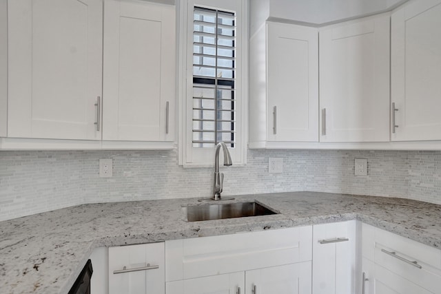 kitchen featuring white cabinetry, sink, and tasteful backsplash