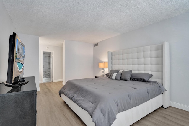 bedroom featuring a textured ceiling and light wood-type flooring