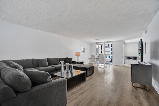 living room featuring a textured ceiling and light wood-type flooring